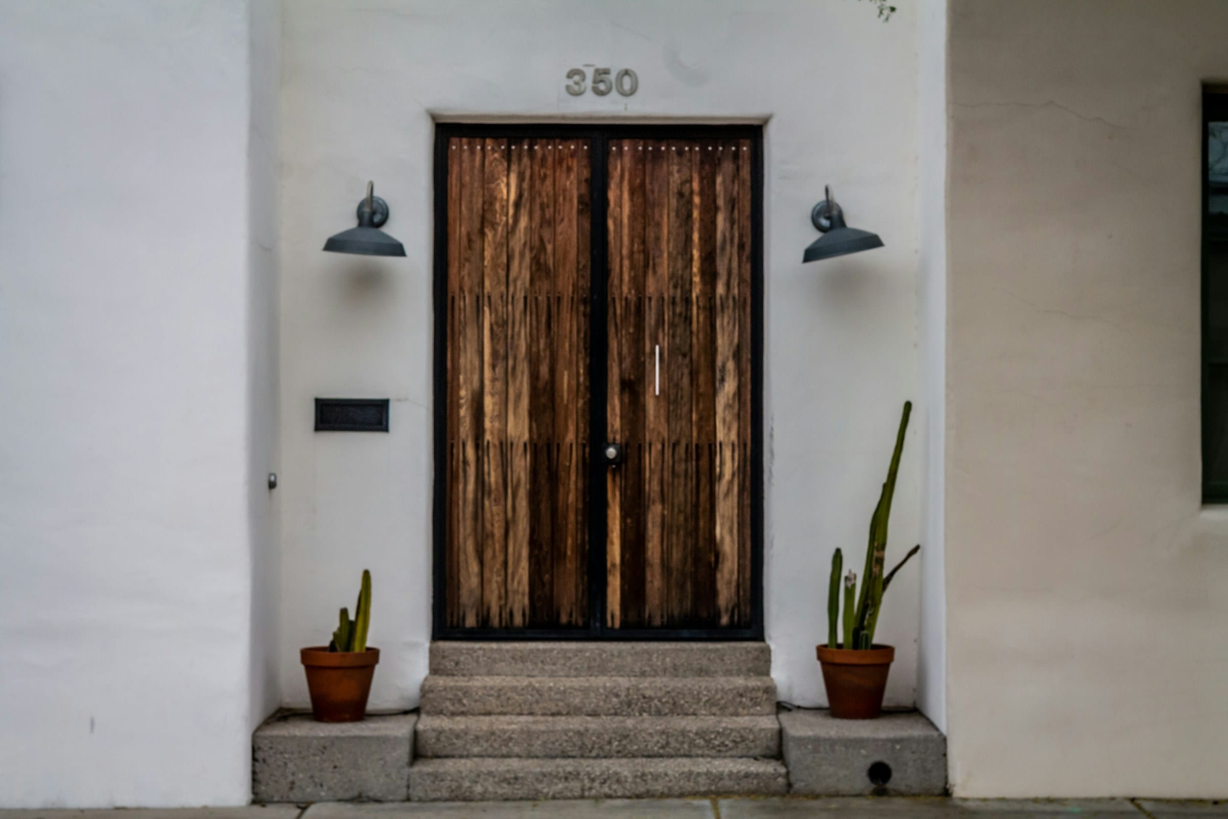 Wooden front door numbered 350 on a white stucco wall
